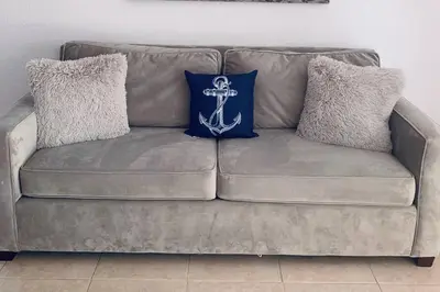 a brown couch with two pillows on it at Coastal Cabana in Hollywood
