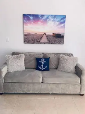 a couch in a living room with a picture on the wall at Coastal Cabana in Hollywood