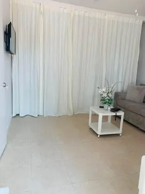 a living room with a couch and a table with flowers at Coastal Cabana in Hollywood
