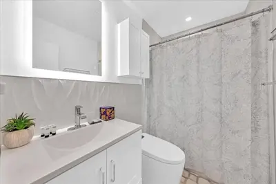 a bathroom with a toilet and a sink and a shower at Sunny Days Getaway, 5BD Heated Pool Family Home! in Fort Lauderdale