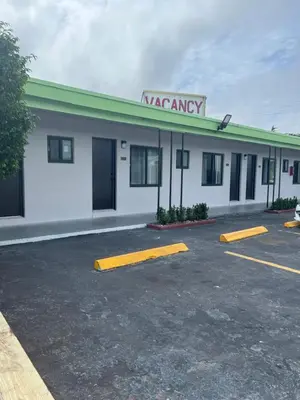 a white building with a vacancy entry sign on it at Vacation Inn motel - FT Lauderdale Airport and Cruise port in Fort Lauderdale
