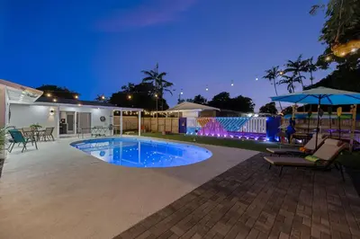 a swimming pool in the middle of a yard at night at Spacious 4BR Waterfront Home with Private Pool, Tiki Hut & Free Parking near Miami & Key Largo in Cutler Bay