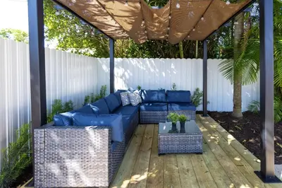 a pergola with a blue couch on a wooden deck at Casa Bora Bora - Fun in Miami - Big Pool - Fit 12 in Miami