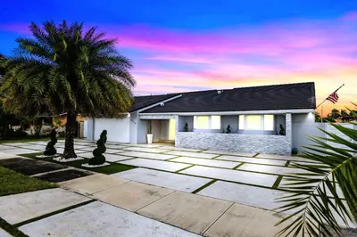 a house with a palm tree in front of it at Gables Paradise - Htd Pool,5 Bdrooms ,Mini Golf, Playground, Baby Items, BBQ in Tamiami