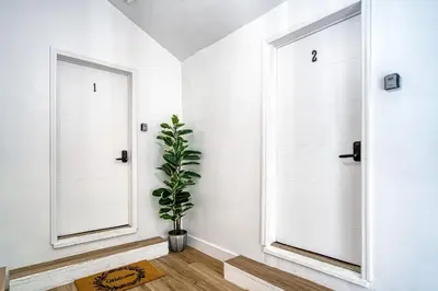 a hallway with two white doors and a potted plant at Casa Roselle On The Beach Full 22 in Hollywood