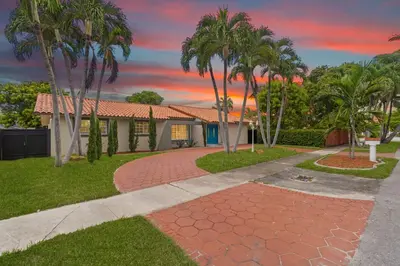 a house with palm trees and a walkway at Casa Maldivas - Blue Oasis - Heated Pool in Tamiami