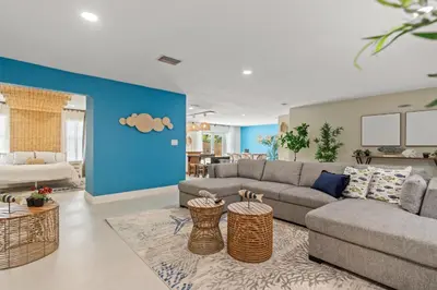 a living room with a gray couch and a blue wall at Casa Maldivas - Blue Oasis - Heated Pool in Tamiami
