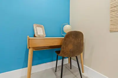 a wooden desk with a chair next to a wall at Casa Maldivas - Blue Oasis - Heated Pool in Tamiami