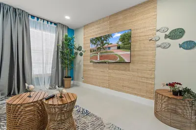 a living room with a tv on a wall at Casa Maldivas - Blue Oasis - Heated Pool in Tamiami