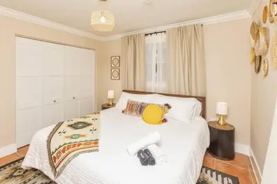 a bedroom with a white bed with a yellow hat on it at Casa Mexican home - Big Pool - Hot Tub - FITS 12 in Miami