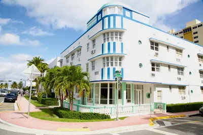 a white building with blue accents on a street at Miami New Beach Stay 3 min to Ocean in Miami Beach