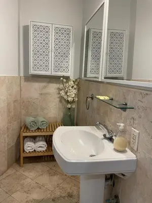 a bathroom with a sink and a shelf with towels at TROPICAL HAVEN POOL & 2BLOCKS TO BEACh in Miami Beach