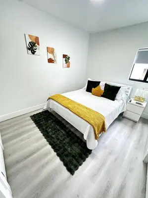 a white bedroom with a bed with a green rug at Artful Luxury in Miami Most Iconic Spot in Miami