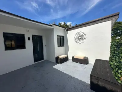 a white building with two stools on a patio at Artful Luxury in Miami Most Iconic Spot in Miami