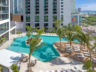an overhead view of a swimming pool with palm trees and buildings at Trendy Escape with Pool Gym 24th-Floor Views in Miami