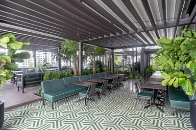 a patio with tables and chairs and plants at Trendy Escape with Pool Gym 24th-Floor Views in Miami