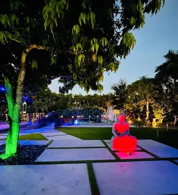 a person sitting on a bench next to a tree at Lake Of Dreams Miami House in Miami