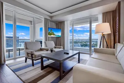 a living room with a couch and chairs and windows at Beachfront Condo Fort Lauderdale in Fort Lauderdale
