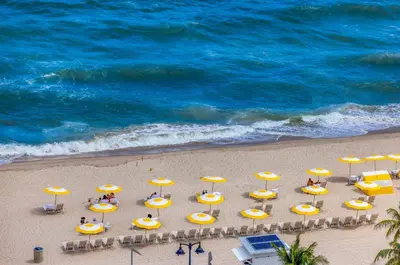 an overhead view of a beach with chairs and umbrellas at Beachfront Condo Fort Lauderdale in Fort Lauderdale