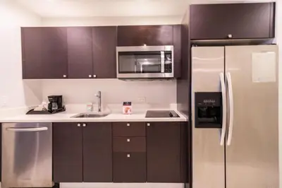 a kitchen with brown cabinets and a stainless steel refrigerator at Doral Pool 1407 by WaveProperties in Miami