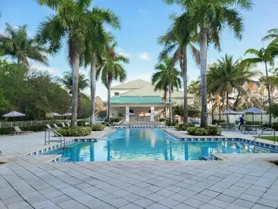 a swimming pool with palm trees in front of a building at Doral Pool 1407 by WaveProperties in Miami