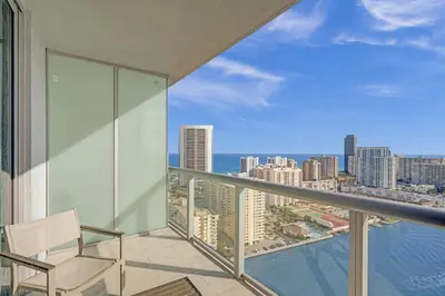 a balcony with a chair and a view of the city at Beachwalk Resort in Hallandale Beach