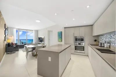 a kitchen and living room with a view of the ocean at Amazing Oceanfront Views From 24th floor! in Hollywood