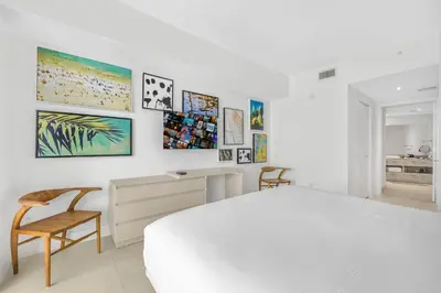 a white bedroom with a bed and a desk and chairs at Amazing Oceanfront Views From 24th floor! in Hollywood