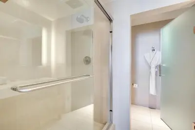a bathroom with a shower and a white robe at Balcony with Ocean View Fort Lauderdale Oasis! in Fort Lauderdale