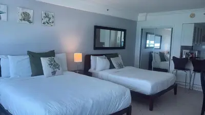 a hotel room with two beds and a mirror at Castle 732 Ocean View with pool, tennis, beach access, FREE parking in Miami Beach