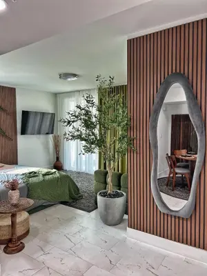 a bedroom with a bed and a mirror and a table at MONROE APART HOTEl in Hollywood