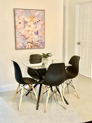 a dining room table with four chairs and a painting at New Brisa Marina in Fort Lauderdale