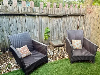two chairs sitting in a yard next to a fence at New Brisa Marina in Fort Lauderdale
