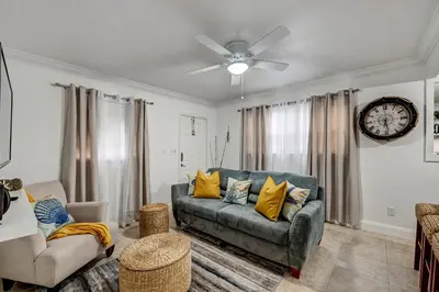 a living room with a couch and a clock on the wall at Hidden Getaway in Fort Lauderdale