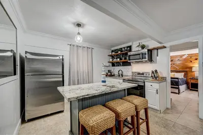 a kitchen with a stainless steel refrigerator and stools at Hidden Getaway in Fort Lauderdale