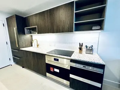a kitchen with wooden cabinets and a counter top at 48th Floor PH collection 1 BD Brand New Downtown in Miami