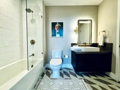 a bathroom with a toilet and a sink and a mirror at 48th Floor PH collection 1 BD Brand New Downtown in Miami
