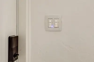 a white light switch on a white door at The Peacock Bungalow Near Fort Lauderdale Beach! in Fort Lauderdale
