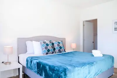 a bedroom with a blue bed with two lamps at Entire House with Free Parking at North Miami! in Miami