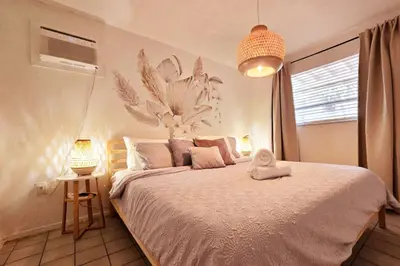 a bedroom with a bed with a flower mural on the wall at Hidden Tropical Gem Calle Ocho 1 in Miami