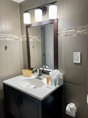 a bathroom with a sink and a mirror at Spacious 3 BR plus 1 office and 2 BA with Free parking Just in front beach in Sunny Isles Beach