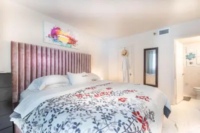 a bedroom with a large bed with a floral bedspread at Cozy Apartment on South Beach in Miami Beach