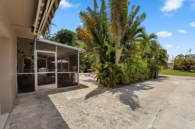 a house with a palm tree next to a building at MIAMI Art Villa Heated Saltwater Pool with SPA EV in Dania Beach