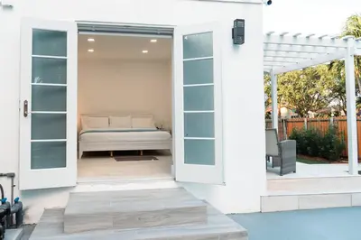 a patio with a door open with a bed in it at Luxury Retreat 3B ,2Ba POOL , Coral Gables Center in Miami