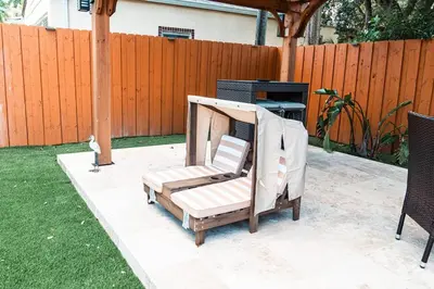 a chair sitting on a patio next to a fence at Luxury Retreat 3B ,2Ba POOL , Coral Gables Center in Miami