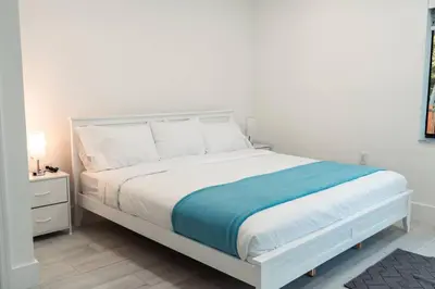 a bedroom with a white bed with a blue blanket at Luxury Retreat 3B ,2Ba POOL , Coral Gables Center in Miami