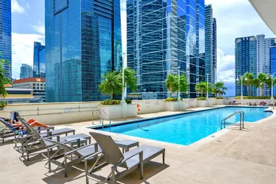 a swimming pool on the roof of a building with tall buildings at Exclusive 1BR Apartment on 35th floor in Miami