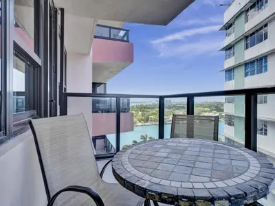 a balcony with a table and chairs on a building at Charming Ocean View Condo with Beach Service 1516 in Miami Beach