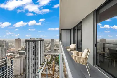 a balcony with chairs and a view of a city at Stunning Condo with Free Parking on 46th Floor! in Miami