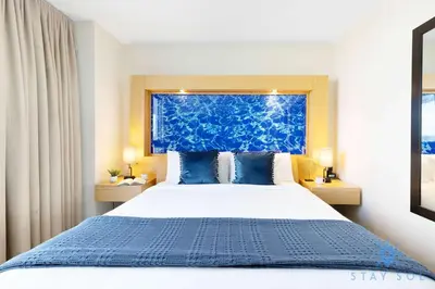 a bedroom with a large bed with a blue headboard at 1BR Apartment with Ocean View in Sunny Isles Beach